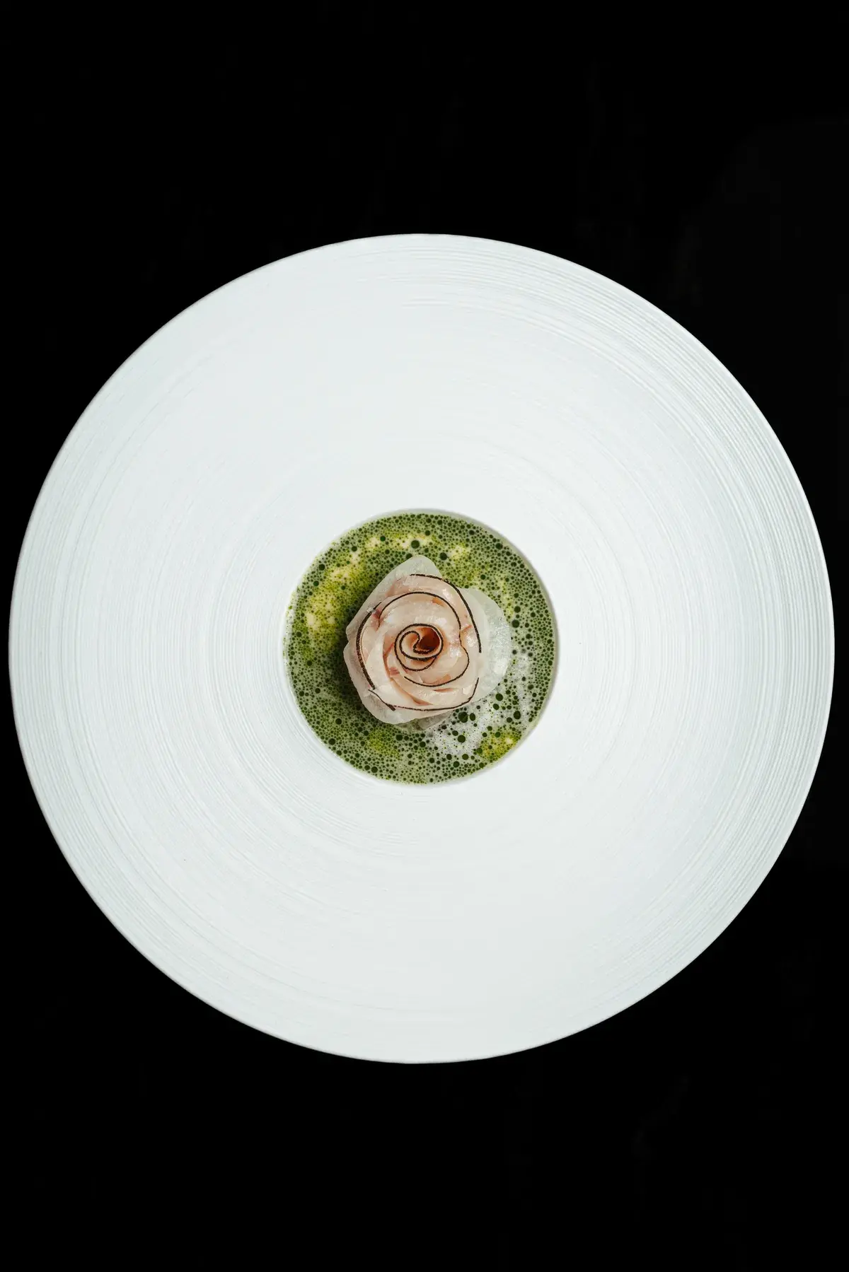 Fein angerichtetes Fischgericht mit Kräuterschaum im Restaurant 141